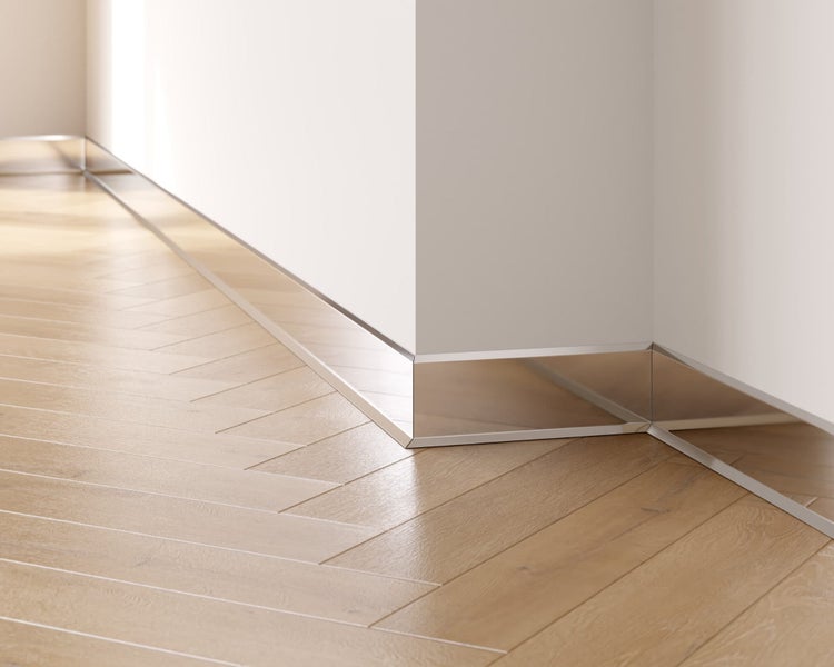 Sockelleiste aus Metall an einer Wand über einem Holzfußboden