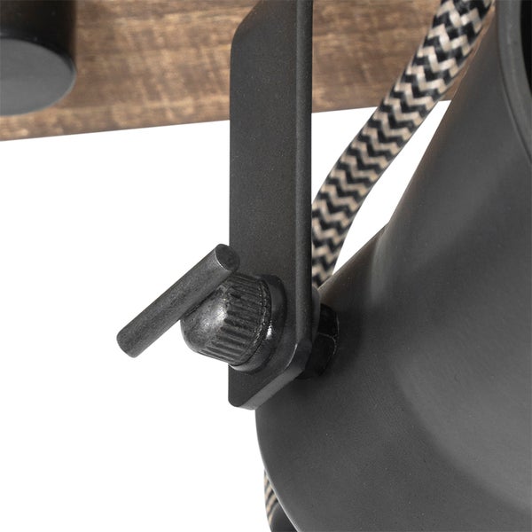 Detailansicht einer Leuchte im Industriestil mit Metallhalterung, verstellbarer Knebelschraube, Textilkabel mit Zickzackmuster und Holzsockel.