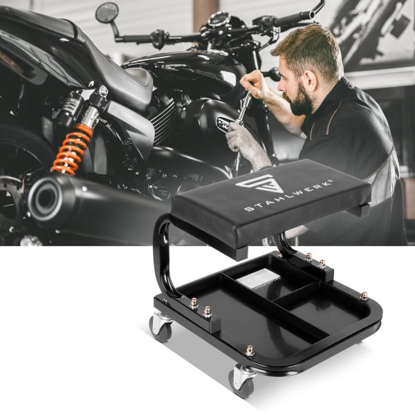 Werkstatthocker mit Ablage unter dem Sitz und ein Mann repariert ein Motorrad