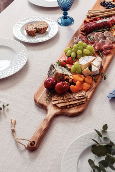 Tisch mit Wurst, Käse, Obst, Brot und Tellern