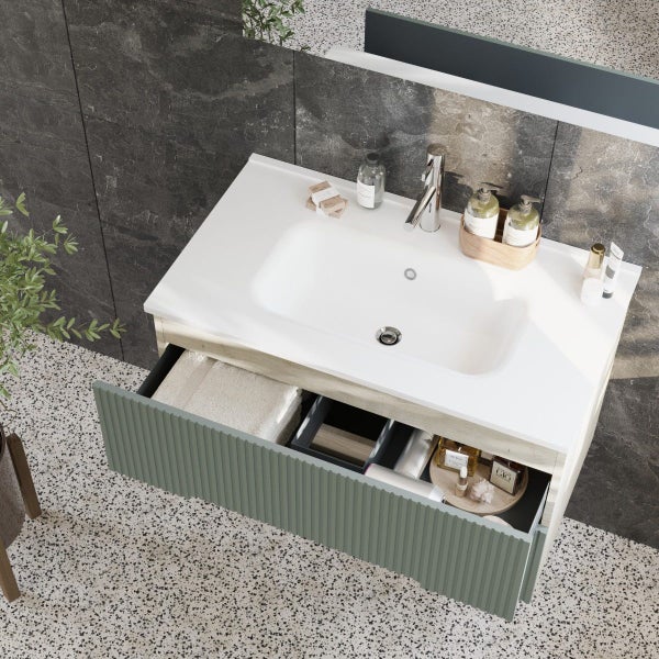 Waschtisch mit Unterschrank in moderner Rillenoptik mit Waschbecken und Armatur in einem Badezimmer mit Terrazzoboden.