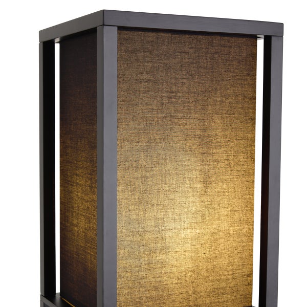 Moderne Tischleuchte mit dunklem Metallrahmen und beleuchtetem, goldbraunem Stoffschirm in strukturierter Optik.