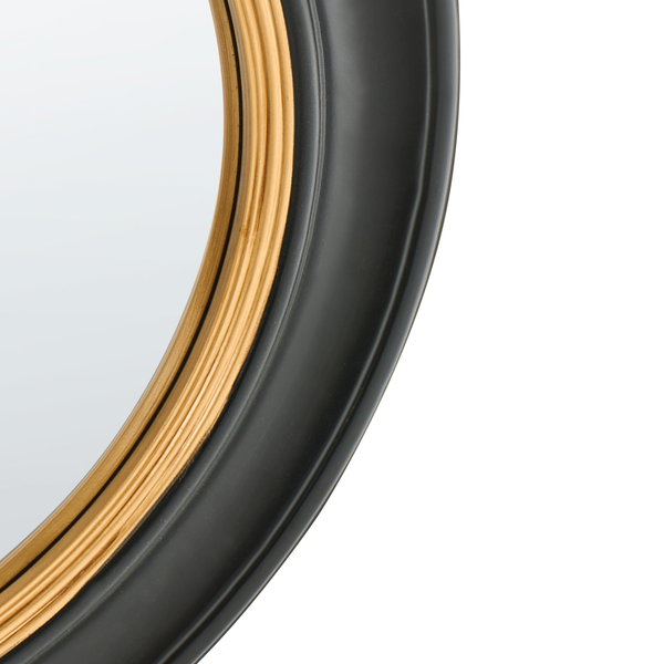 Detailansicht eines runden Spiegels mit einem Rahmen in Schwarz und Gold.