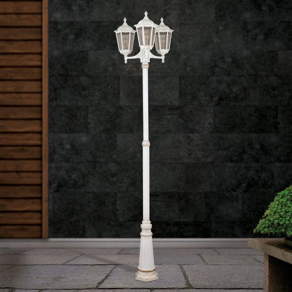 Weißer dreiflammiger Kandelaber aus Metall im klassischen Design für den Außenbereich auf einer Terrasse.