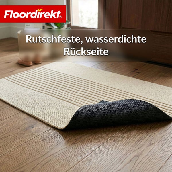 Floordirekt Logo. Eine rechteckige Fußmatte mit Streifenmuster auf Holzboden, rutschfeste und wasserdichte Rückseite sichtbar.