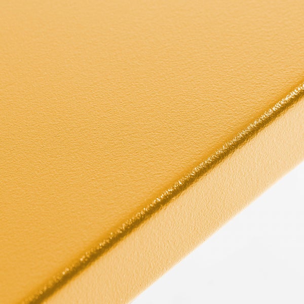 Detailaufnahme einer goldfarbenen, strukturierten Oberfläche an der Kante eines Paneels oder einer Küchenrückwand.