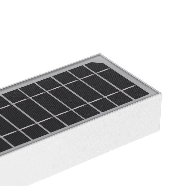Nahaufnahme eines rechteckigen Solarpanels auf einer weißen Außenwandleuchte.