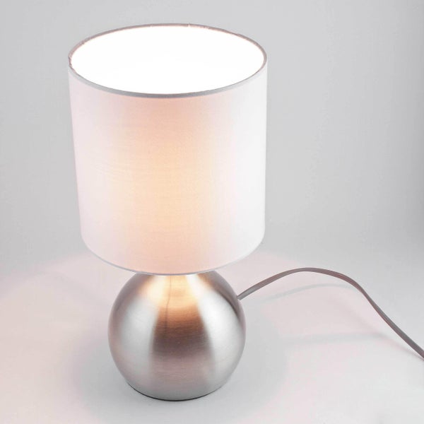 Tischleuchte mit rundem, silberfarbenem Sockel und Lampenschirm
