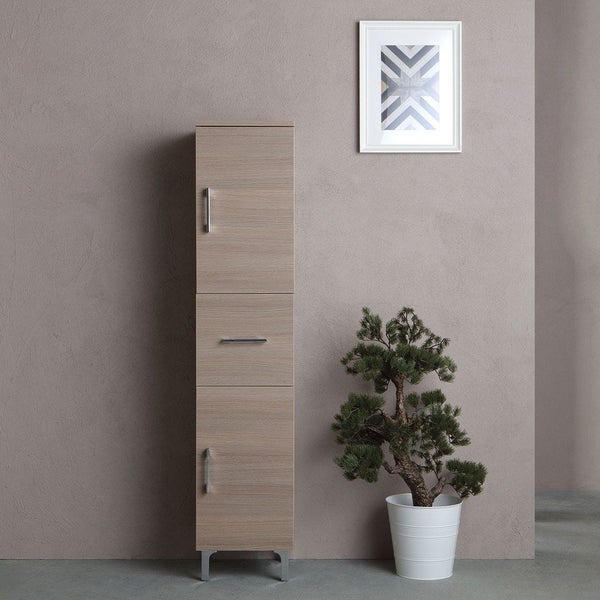Hoher Badezimmerschrank mit Tür und Schublade neben einer Zimmerpflanze und einem gerahmten Bild