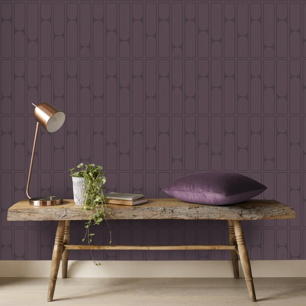 Szene mit einer Holzbank, einer Lampe, einer Pflanze, Büchern, einem Kissen und einer gemusterten Tapete