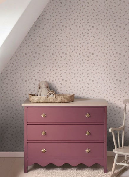 Kinderzimmer mit Blumentapete, Holzschrank in Mauve, Wandpaneel mit Kleiderhaken und weißem Holzboden.