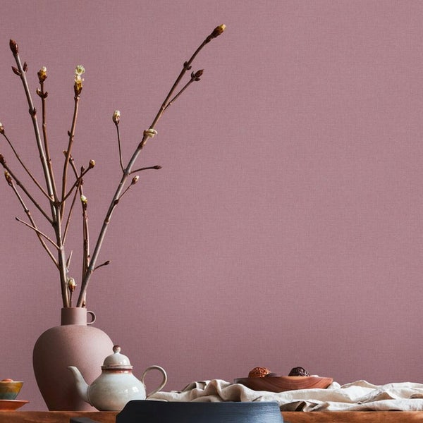 Stillleben mit Vase, Zweigen und Geschirr auf einem Tisch vor einer Wand