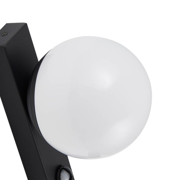 Nahaufnahme einer modernen Außenwandleuchte mit weißem Kugelschirm und schwarzer Metallhalterung mit Bewegungsmelder.