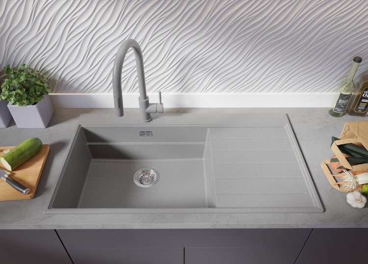 Spüle aus Stein mit Abtropffläche und Armatur auf einer Küchentheke