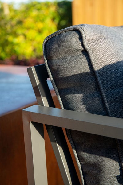 Detailansicht eines Gartenstuhls mit grauem Metallrahmen und strukturiertem Stoffkissen.