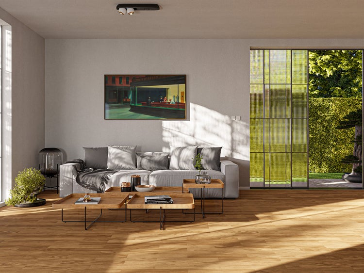 Modernes, helles Wohnzimmer mit Holzfußboden, Sofa, Holztischen und einer großen Glasfront zum Garten.