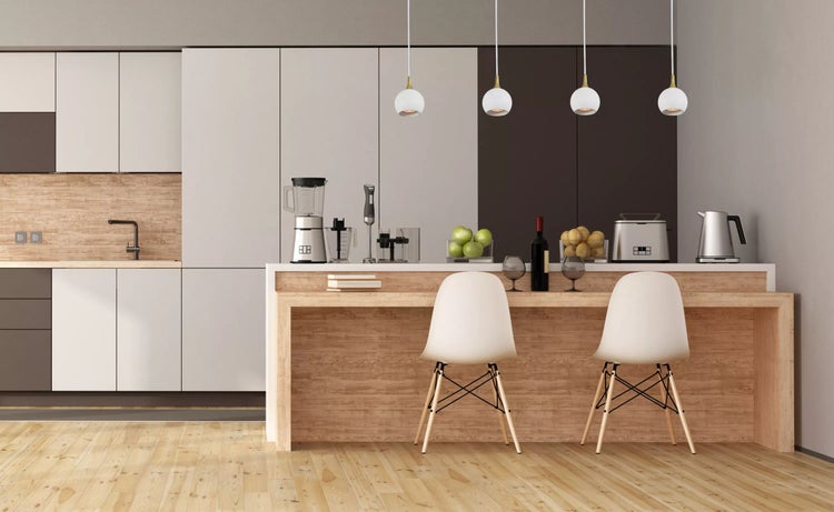 Helle Küche mit Küchengeräten, Esstisch, Stühlen und Pendelleuchten