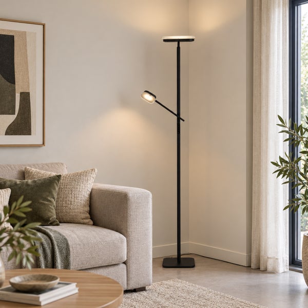 Moderne Deckenfluter Stehleuchte mit Leselicht in einem elegant eingerichteten Wohnzimmer neben einem Sofa mit Zierkissen.