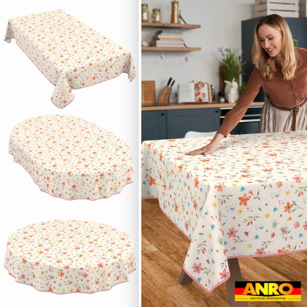 Abwaschbare Tischdecke mit Blumenmuster in rechteckiger, ovaler und runder Ausführung. Frau glättet die Decke auf einem Tisch. ANRO Logo.