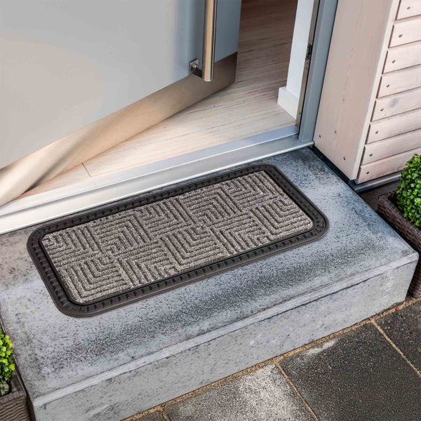 Fußabtreter mit geometrischem Muster vor einer geöffneten Tür