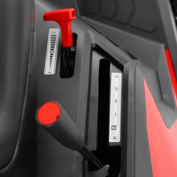 Bedienfeld eines Aufsitzmähers mit Gashebel und Gangschalthebel für Geschwindigkeiten und Fahrtrichtung.