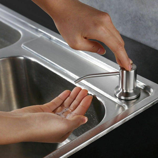 Einbau Seifenspender aus Edelstahl an einem Edelstahl Spülbecken montiert wird mit der Hand bedient