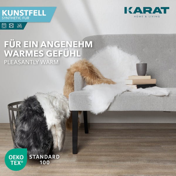 Karat Home und Living Logo. Kunstfelle auf grauem Sofa und in Korb. Oeko-Tex Standard 100 zertifiziert. Hell und gemütlich.