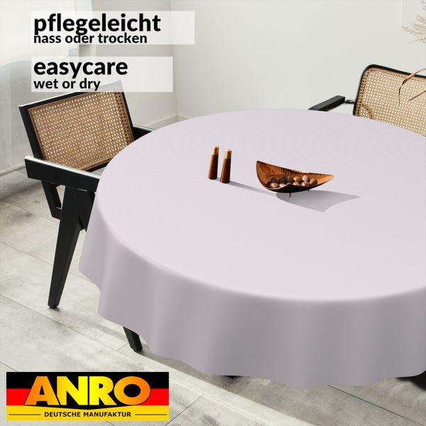 Runde Tischdecke auf einem Esstisch, pflegeleicht nass oder trocken abwischbar, ANRO DEUTSCHE MANUFAKTUR Logo.