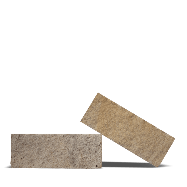 Rechteckige Mauersteine aus Naturstein mit rauer Oberfläche in Beigetönen.