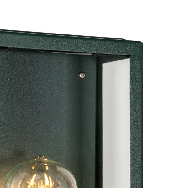 Detailansicht einer grünen, rechteckigen Wandleuchte mit strukturiertem Metallrahmen, Glaseinsatz und Filament-Leuchtmittel.