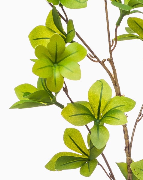 Künstlicher Zweig mit grünen Blättern an einem braunen Stiel.