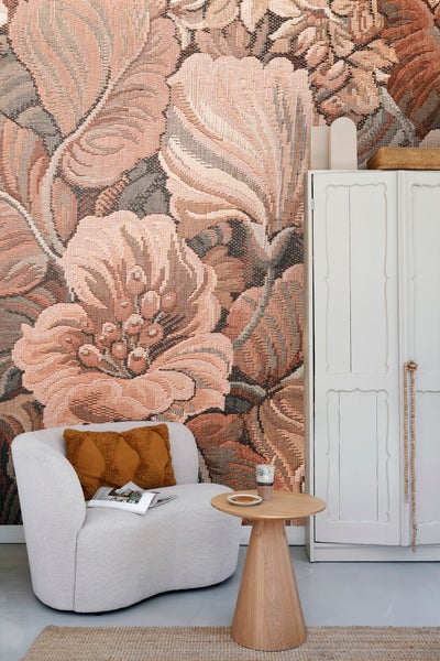 Wohnzimmer mit Sessel, Beistelltisch und floraler Tapete