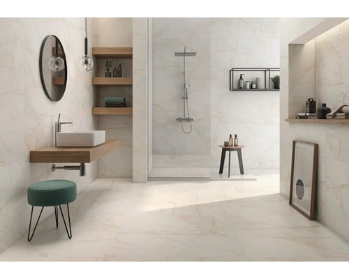 Modernes, helles Badezimmer mit Wand- und Bodenfliesen in Marmoroptik, begehbarer Dusche, Holzwaschtisch und rundem Spiegel.