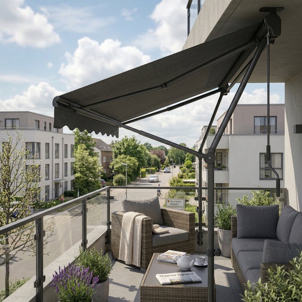 Moderne Klemmmarkise auf einem hellen Balkon mit grauen Lounge-Möbeln aus Geflecht, Pflanzen und Blick auf eine Wohnstraße.