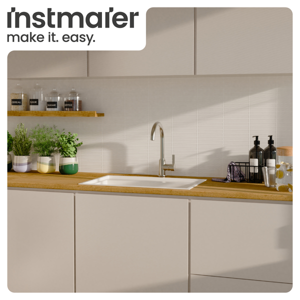 Helle, moderne Küche mit Instmaier Logo, Arbeitsplatte in Holzoptik, weißer Einbauspüle, hoher Armatur und einem modernen Fliesenspiegel.