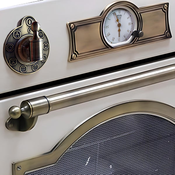 Backofentür eines Einbaubackofens im Landhausstil mit analoger Uhr und Drehregler in antiker Metalloptik