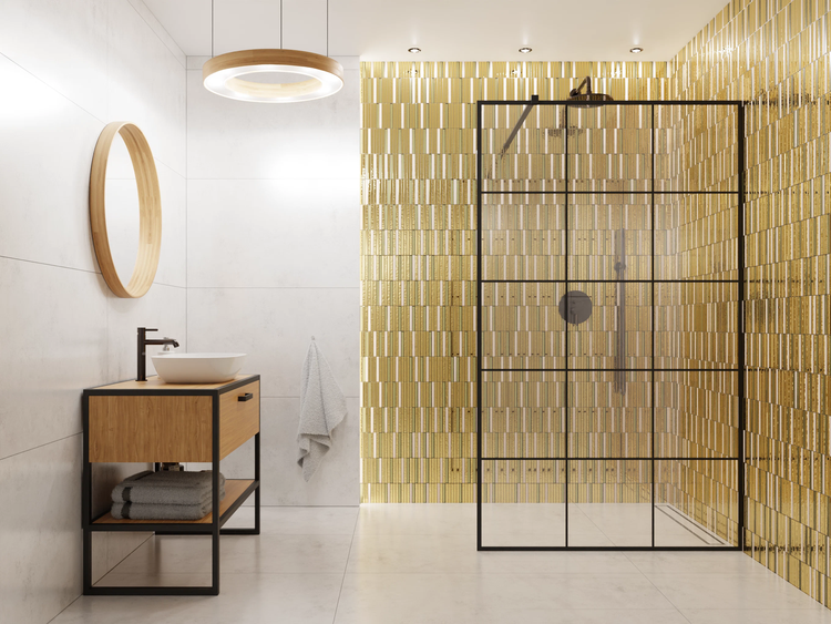 Badezimmer mit Holz-Waschtisch, Aufsatzbecken, rundem Spiegel, Walk-In-Dusche mit schwarzem Rahmen und Wand aus goldenen Mosaikfliesen.