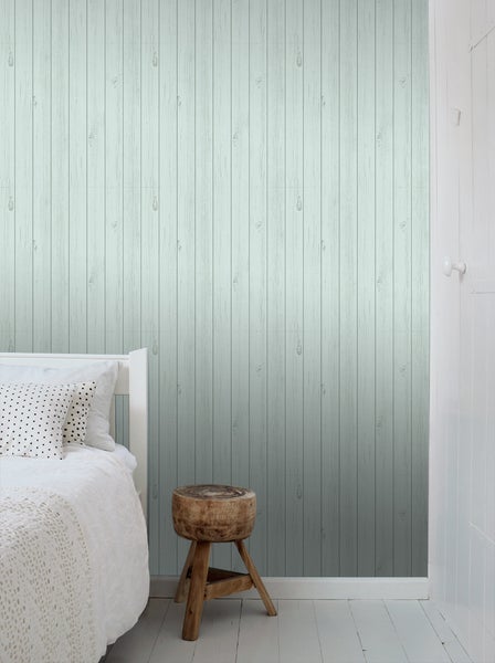 Helles Schlafzimmer mit Holztapete, Bett und Hocker