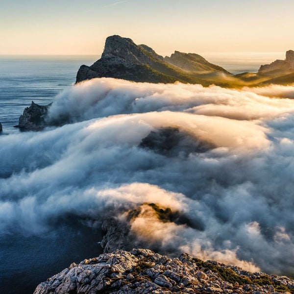 Berge, Meer und Wolken in einer Landschaft.