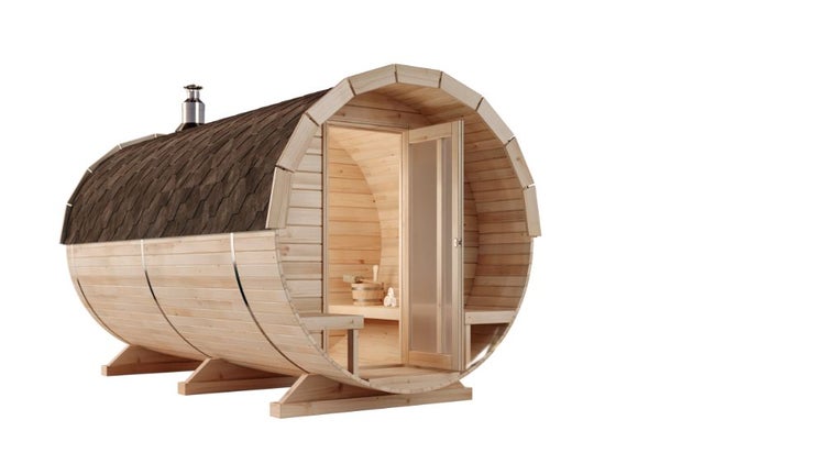 Fasssauna aus hellem Holz mit dunklem Schindeldach, Schornstein und offener Glastür.