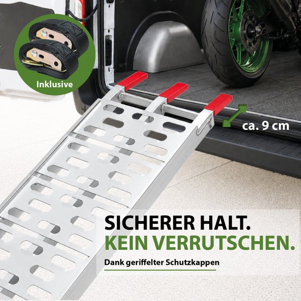 Aluminium-Auffahrschiene mit gelochter Oberfläche, roten Schutzkappen und zwei inkludierten Spanngurten an einem Fahrzeugheck.