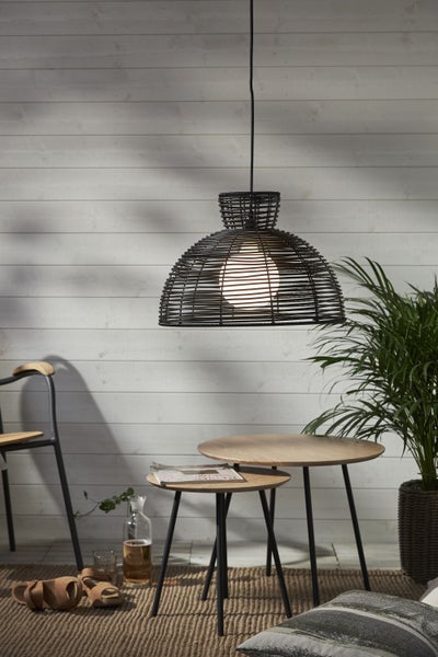 Wohnraum mit schwarzer Draht-Hängeleuchte, Holztischen und Zimmerpflanze
