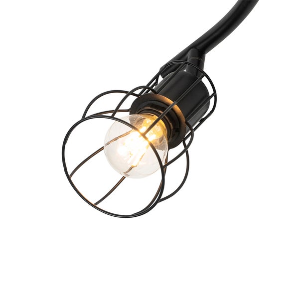 Nahaufnahme einer schwarzen Gitterlampe mit eingeschalteter Glühbirne