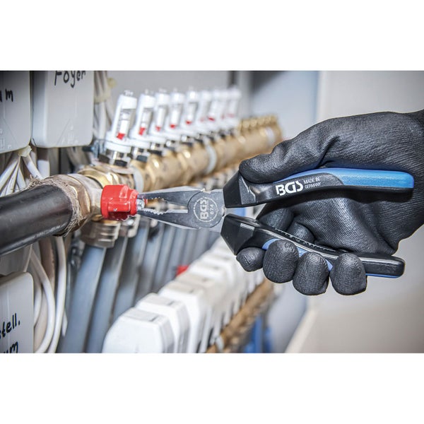 Eine Hand mit Handschuh benutzt eine Kombinationszange der Marke BGS zum Bearbeiten eines Rohres.