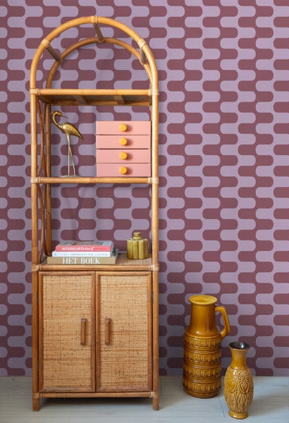 Bambusregal mit zwei Türen, Ablagen und Deko-Objekten vor gemusterter Wand