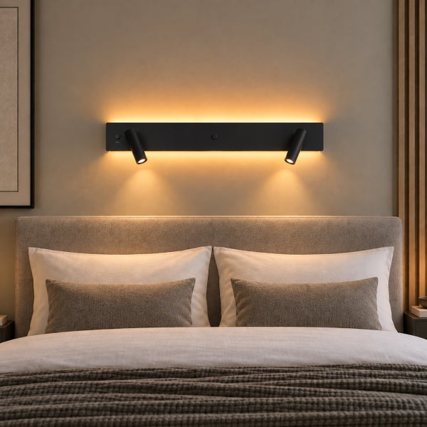 Moderne Wandleuchte mit zwei Spots und indirekter Hintergrundbeleuchtung über einem gepolsterten Bett in einem Schlafzimmer.