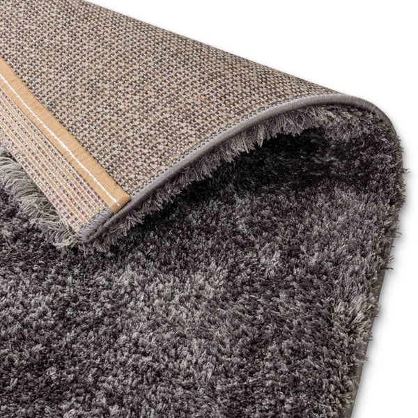 Hochflor-Teppich Shaggy in Anthrazit mit gewebter Rückseite und Kantenverstärkung in der Detailansicht.