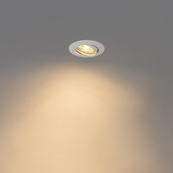 Runder schwenkbarer Einbaustrahler in Weiß, eingeschaltet mit warmweißem Lichtkegel.