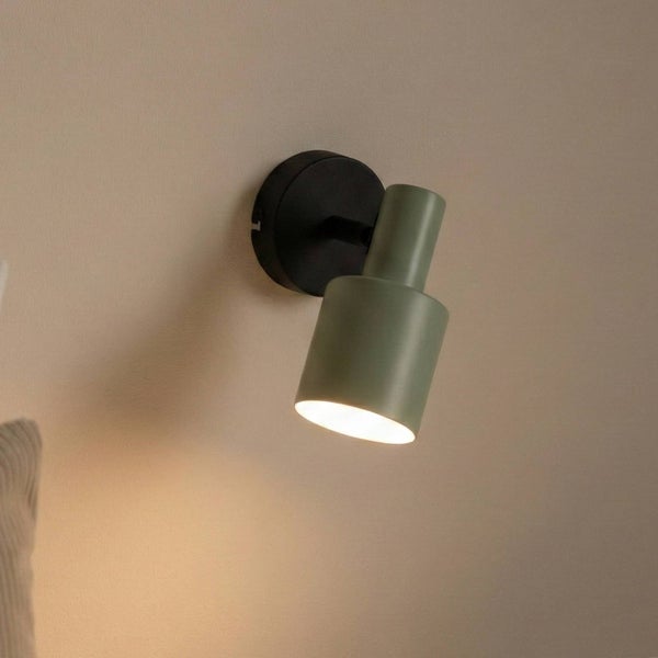 Grüne Wandleuchte mit schwarzer Halterung an der Wand