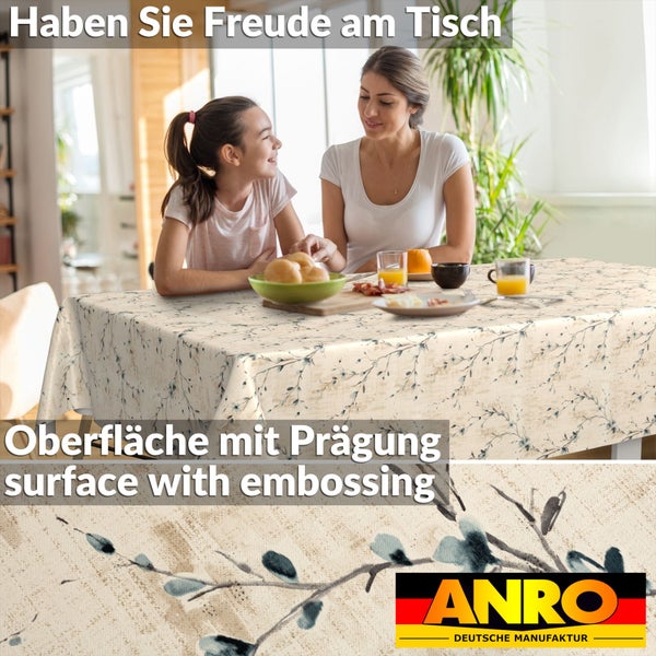 Helle Esszimmerszene mit Mutter und Kind an einem Tisch mit einer ANRO-Tischdecke mit Zweigmuster und geprägter Oberfläche. ANRO Logo.
